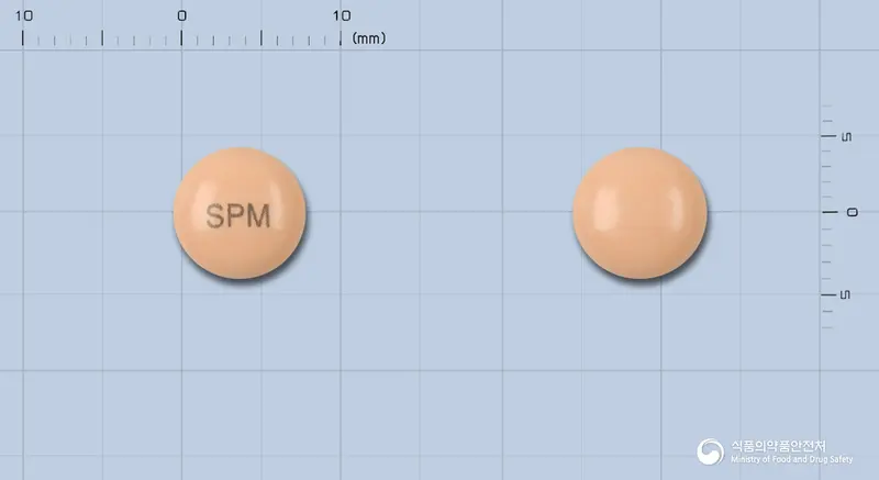 스파몬정(카로베린) 앞뒤 사진 (주황색 원형, 각인 SPM)