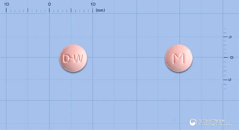메녹틸정(옥틸로늄브롬화물) 앞뒤 사진 (분홍색 원형, 각인 D-W / M)