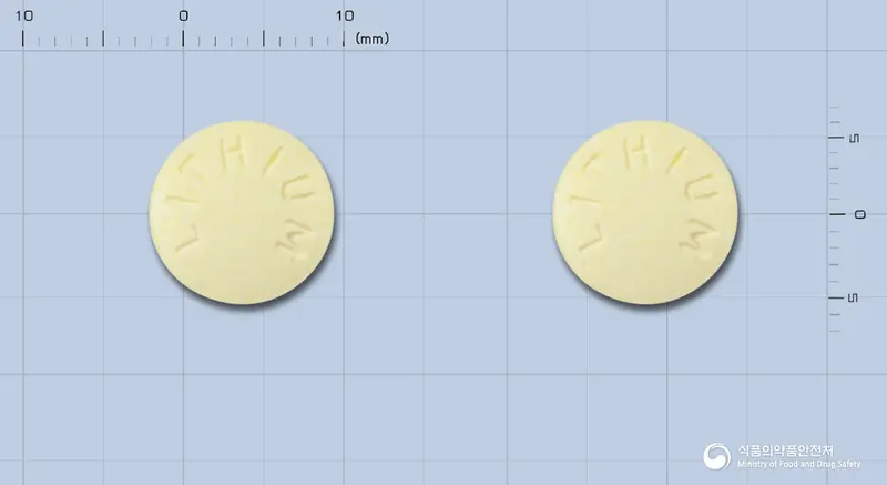 환인탄산리튬정 앞뒤 사진 (노란색 원형, 각인 LITHIUM / LITHIUM)