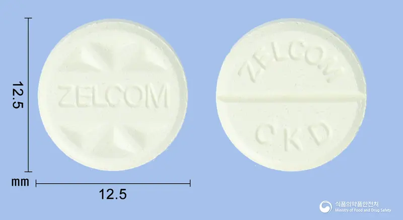 젤콤정(플루벤다졸) 앞뒤 사진 (노란색 원형, 각인 △▽△ZELCOM▽△▽ / ZELCOM CKD)