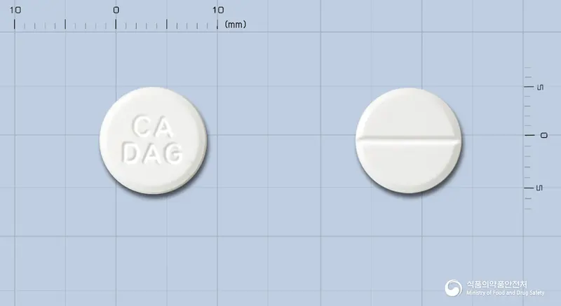 다겔정(건조수산화알루미늄겔) 앞뒤 사진 (흰색 원형, 각인 CADAG)