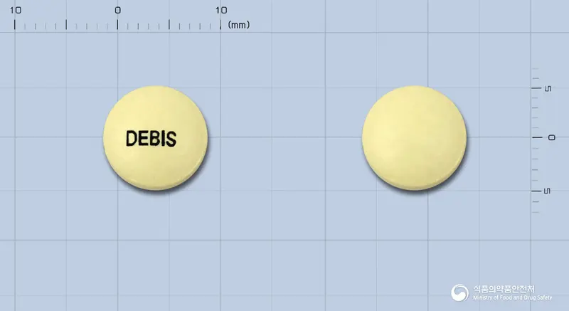 데비스필름코팅정(구연산비스마스칼륨) 앞뒤 사진 (노란색 원형, 각인 DEBIS)