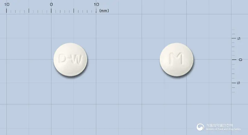 메녹틸정40밀리그램(옥틸로늄브롬화물) 앞뒤 사진 (흰색 원형, 각인 D-W / M)