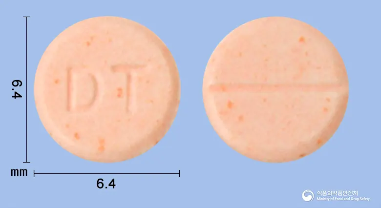 푸마티펜정(케토티펜푸마르산염) 앞뒤 사진 (주황색 원형, 각인 DT)