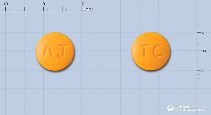탈로신정(탈니플루메이트) 앞뒤 사진 (주황색 원형, 각인 ΛJ / TC)