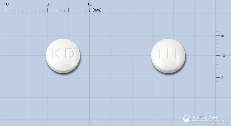 광동타목시펜정20밀리그램(타목시펜시트르산염) 앞뒤 사진 (흰색 원형, 각인 KD / 111)