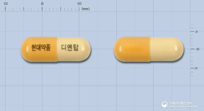 디앤탑캅셀 앞뒤 사진 (노란색 캡슐, 각인 현대약품 디앤탑)