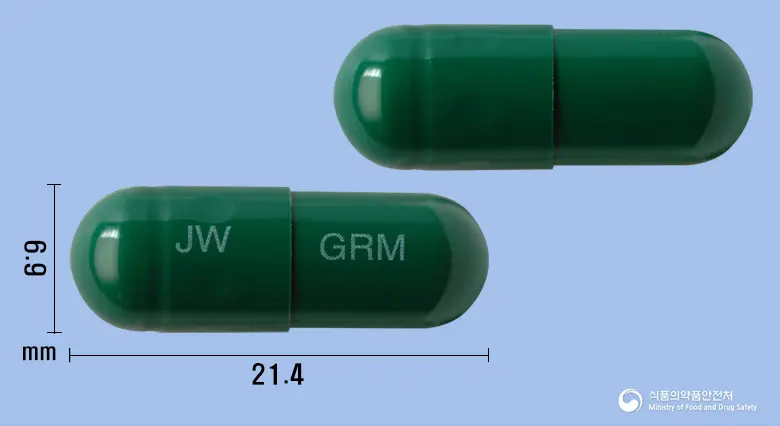그린미캡슐 앞뒤 사진 (초록색 캡슐, 각인 JW GRM)