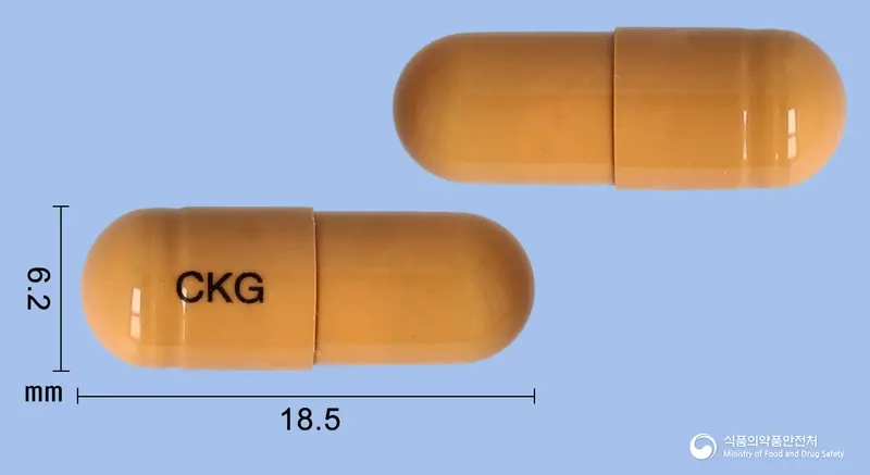 브레이닝캡슐 앞뒤 사진 (주황색 캡슐, 각인 CKG)