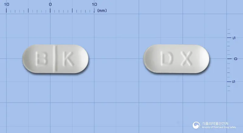 액시마정(독소필린) 앞뒤 사진 (흰색 장방형, 각인 B K / DX)