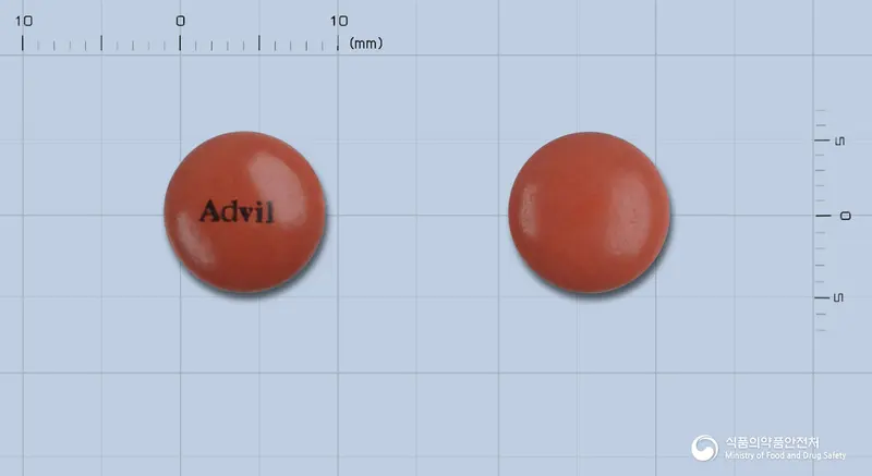애드빌정(이부프로펜) 앞뒤 사진 (주황색 원형, 각인 Advil)