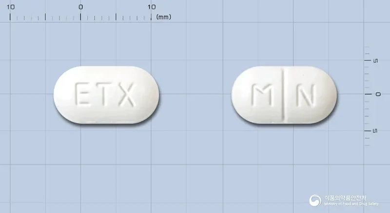 메넥스정(수출용) 앞뒤 사진 (흰색 장방형, 각인 ETX / M N)