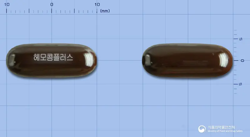 헤모콤플러스연질캡슐(수출명: COMHEMO) 앞뒤 사진 (갈색 캡슐, 각인 헤모콤플러스)
