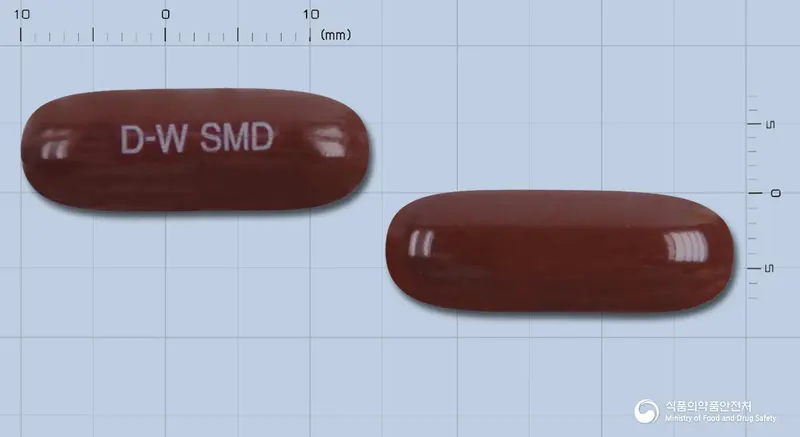 동화실마딘연질캡슐(수출명: CANDINIL soft cap) 앞뒤 사진 (갈색 캡슐, 각인 D-W SMD)