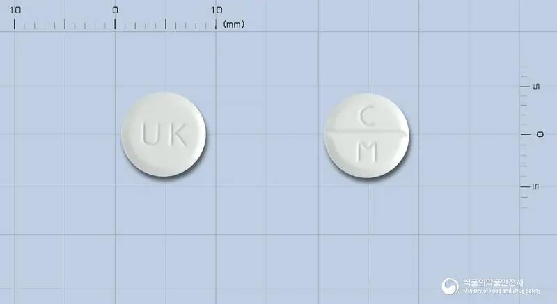 시메트롬정(브롬화시메트로피움) 앞뒤 사진 (흰색 원형, 각인 UK / C M)
