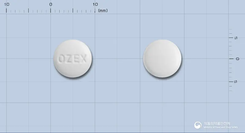 오젝스정(토수플록사신토실산염수화물) 앞뒤 사진 (흰색 원형, 각인 OZEX)