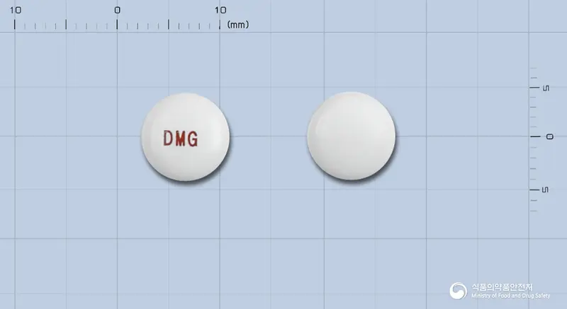디메틴정(디메크로틴산마그네슘) 앞뒤 사진 (흰색 원형, 각인 DMG)
