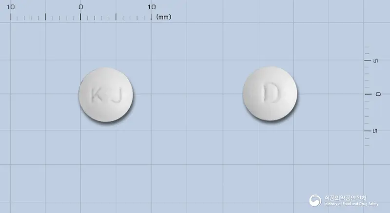 디제탈정(디메크로틴산마그네슘) 앞뒤 사진 (흰색 원형, 각인 KJ / D)