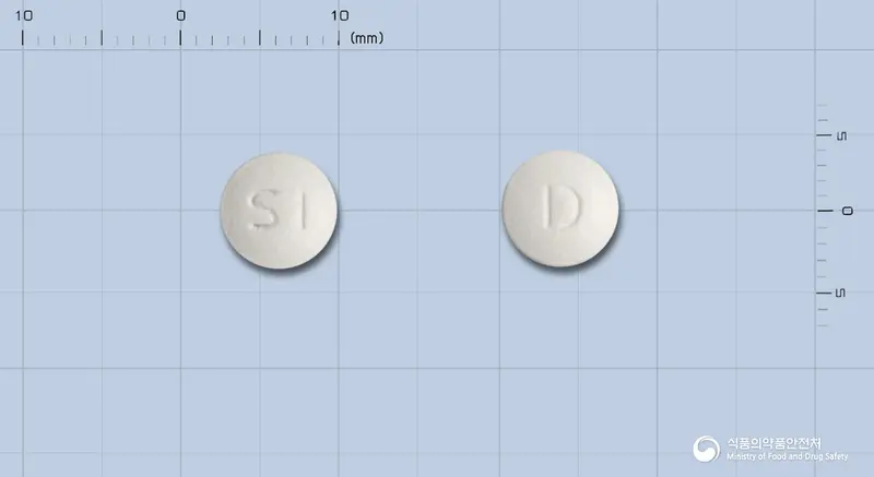 디스멕정(디메크로트산마그네슘) 앞뒤 사진 (흰색 원형, 각인 SI / D)