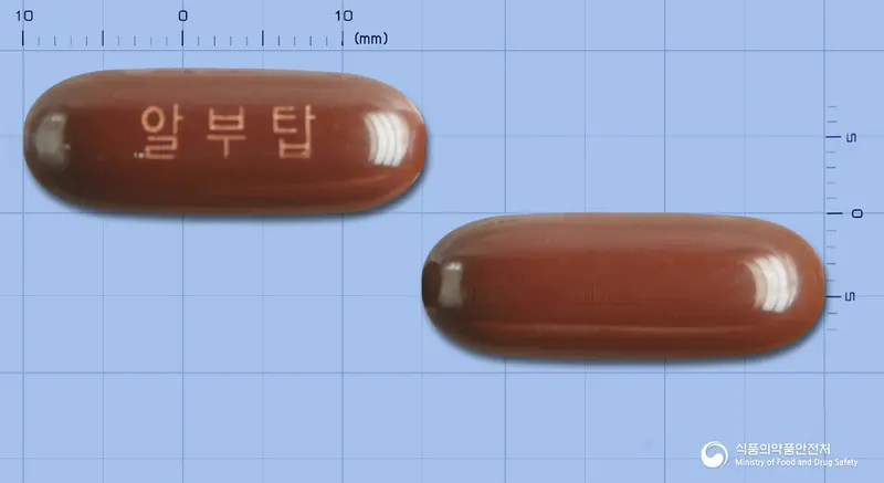 알부탑연질캡슐 앞뒤 사진 (갈색 캡슐, 각인 알부탑)