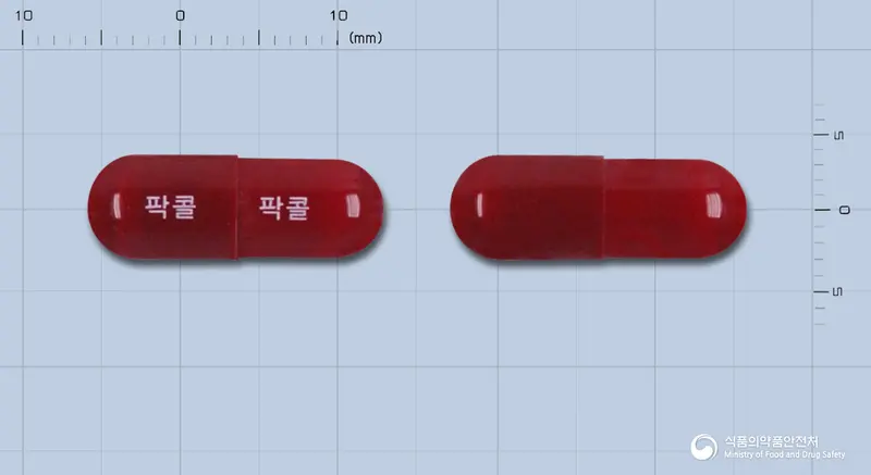 팍콜캡슐 앞뒤 사진 (빨간색 캡슐, 각인 팍콜 팍콜)