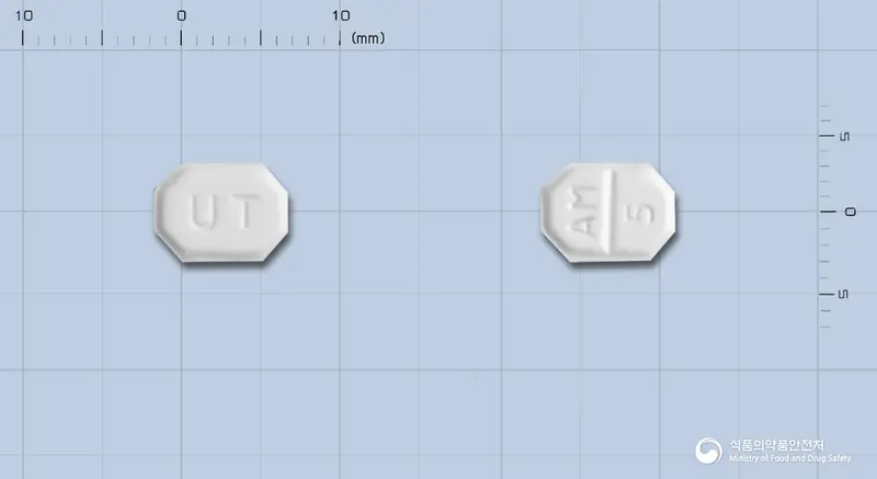 유나스크정5mg(암로디핀베실산염) 앞뒤 사진 (흰색 팔각형, 각인 UT / AM 5)