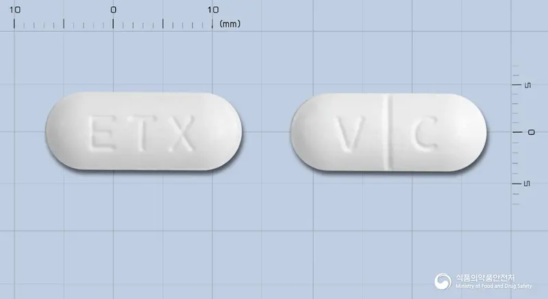 이텍스비타민씨정1000mg(아스코르빈산97%과립) 앞뒤 사진 (흰색 장방형, 각인 ETX / V C)