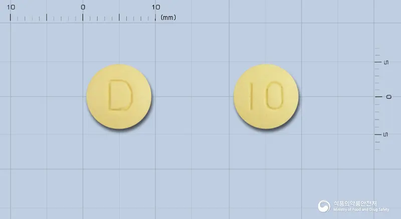 도네필정10밀리그램(도네페질염산염수화물) 앞뒤 사진 (노란색 원형, 각인 D / 10)