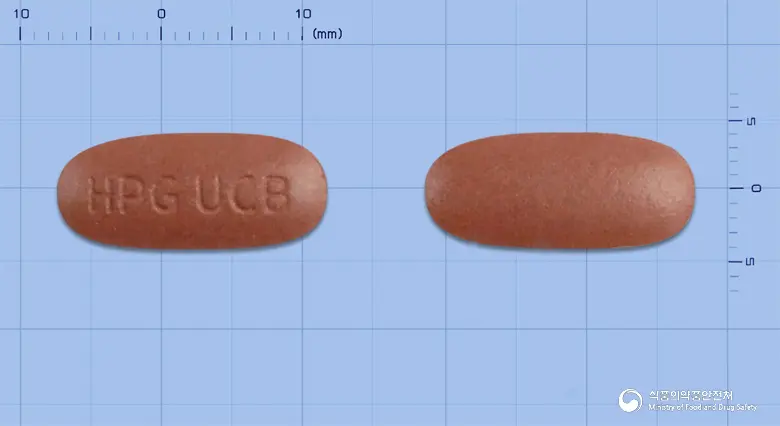 유코빅정 앞뒤 사진 (갈색 타원형, 각인 HPG UCB)