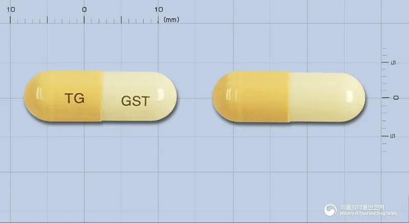 지스탑캡슐 앞뒤 사진 (주황색 캡슐, 각인 TG GST)