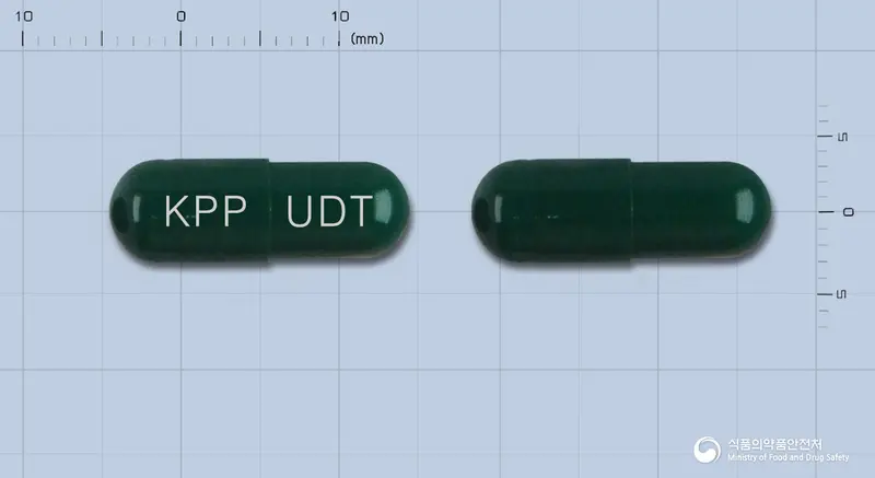 유덴티캡슐(수출용) 앞뒤 사진 (초록색 캡슐, 각인 KPP UDT)