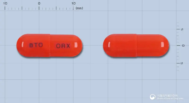 오렉스캡슐 앞뒤 사진 (빨간색 캡슐, 각인 BTO ORX)