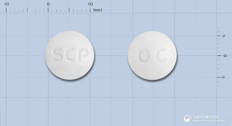 오메코프정 앞뒤 사진 (흰색 원형, 각인 SCP / OC)