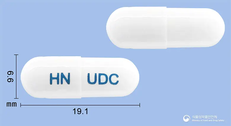 유앤비캡슐 앞뒤 사진 (흰색 캡슐, 각인 HN UDC)