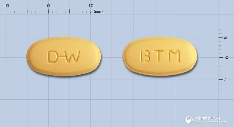 비타미니아정 앞뒤 사진 (노란색 타원형, 각인 D-W / BTM)