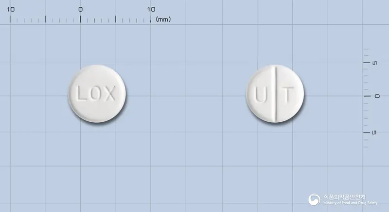 록스핀정(록소프로펜나트륨수화물) 앞뒤 사진 (흰색 원형, 각인 LOX / U T)