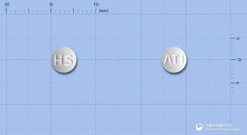 휴온스아토르바스타틴정(아토르바스타틴칼슘삼수화물) 앞뒤 사진 (흰색 원형, 각인 HS / AT1)