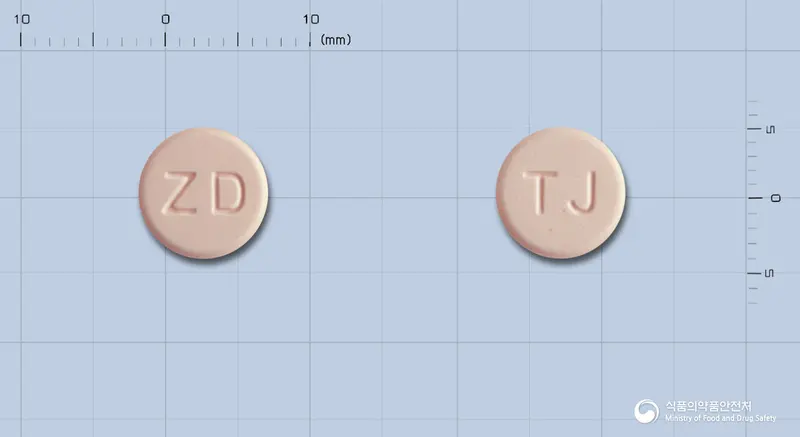 자이다제정(스트렙토키나제·스트렙토도르나제) 앞뒤 사진 (분홍색 원형, 각인 ZD / TJ)
