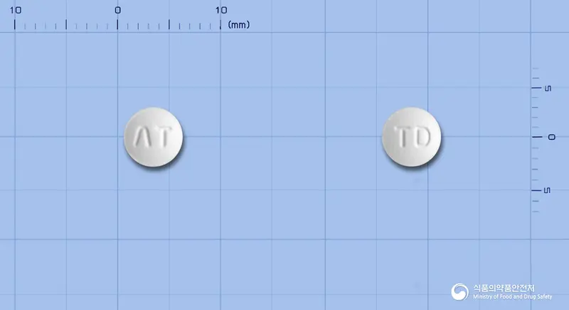 아토바스정10mg(아토르바스타틴칼슘수화물) 앞뒤 사진 (흰색 원형, 각인 ΛT / TD)