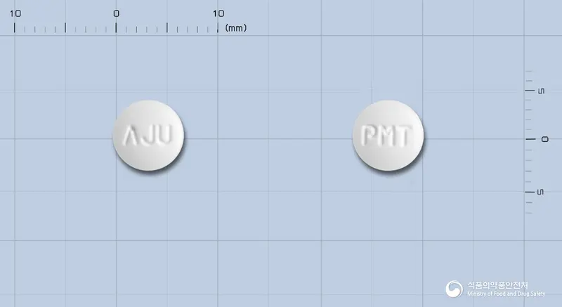 파라몬정(리마프로스트알파덱스) 앞뒤 사진 (흰색 원형, 각인 ΛJU / PMT)
