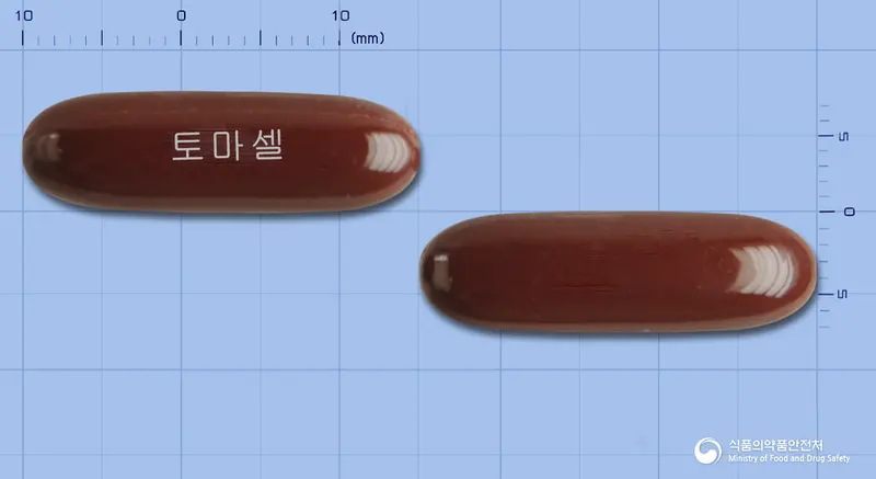 토마셀연질캡슐 앞뒤 사진 (갈색 캡슐, 각인 토마셀)
