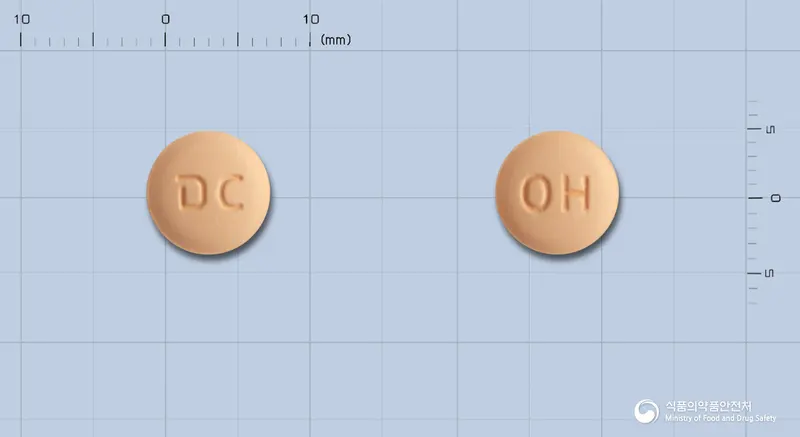 오메조탄플러스정 앞뒤 사진 (주황색 원형, 각인 DC / OH)