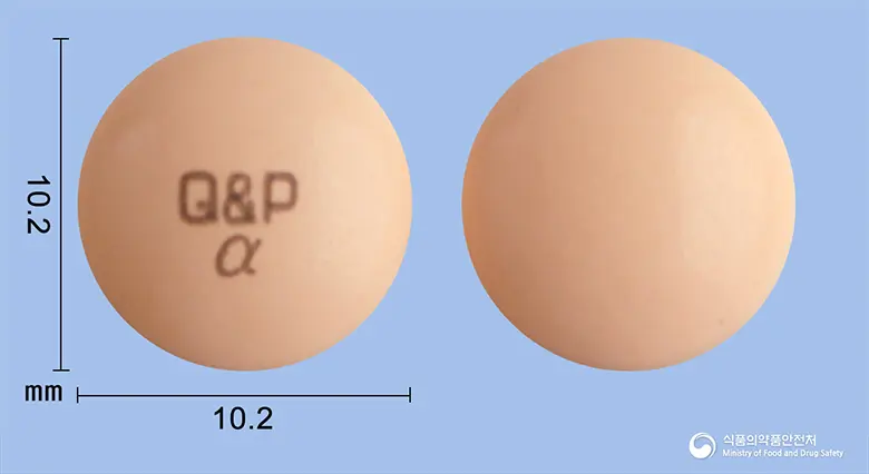 큐피코와골드알파정 앞뒤 사진 (분홍색 원형, 각인 Q&P α)