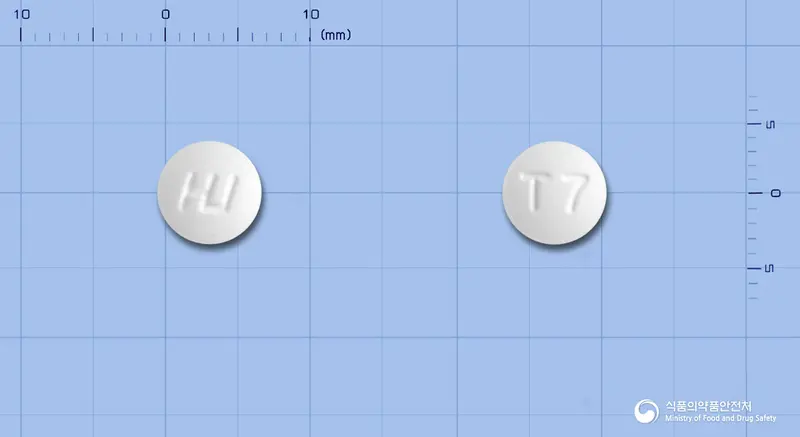 티로미정(티로프라미드염산염) 앞뒤 사진 (흰색 원형, 각인 T7)