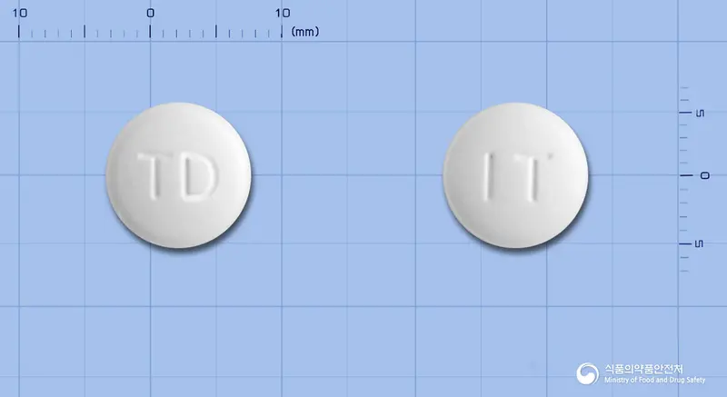 트리코나정(이트라코나졸고체분산체) 앞뒤 사진 (흰색 원형, 각인 TD / IT)