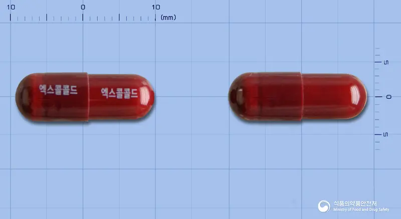 엑스콜콜드에프캡슐 앞뒤 사진 (빨간색 캡슐, 각인 엑스콜콜드 엑스콜콜드)
