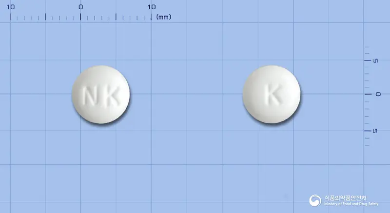 카로나제정(칼리디노게나제) 앞뒤 사진 (흰색 원형, 각인 NK / K)