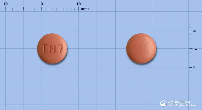 올메디퀄정10/40밀리그램 앞뒤 사진 (주황색 원형, 각인 TH7)