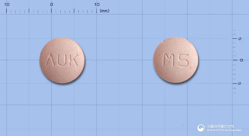몬테스코츄정5mg(몬테루카스트나트륨) 앞뒤 사진 (분홍색 원형, 각인 ΛUK / M5)