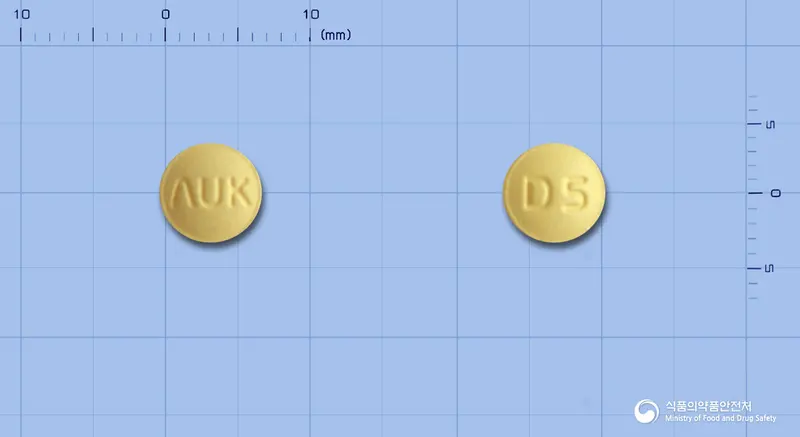 오코셉트정5mg(도네페질염산염수화물) 앞뒤 사진 (노란색 원형, 각인 ΛUK / D5)